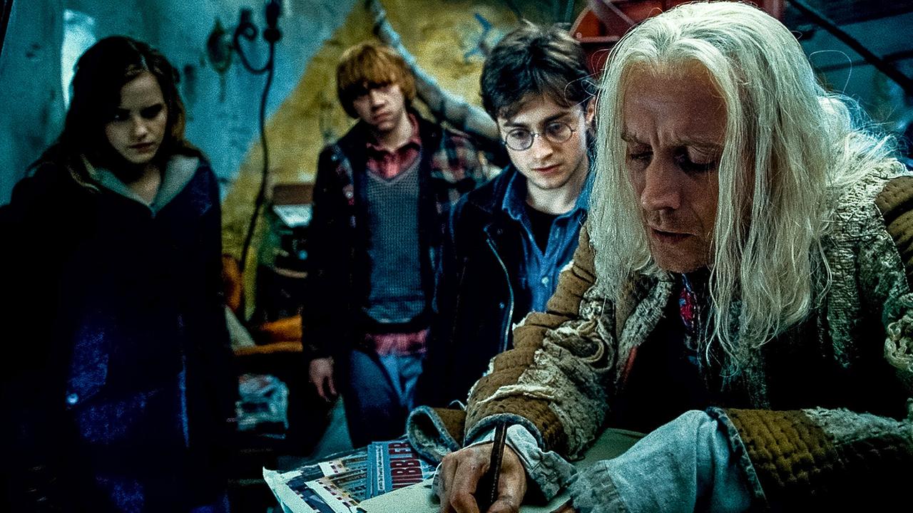 © ORF/Warner Bros. Pictures Hermine Granger, Ron Weasley und Harry Potter besuchen den weißhaarigen Xenohilius Lovegood, der ihnen etwas auf ein Zettel notiert