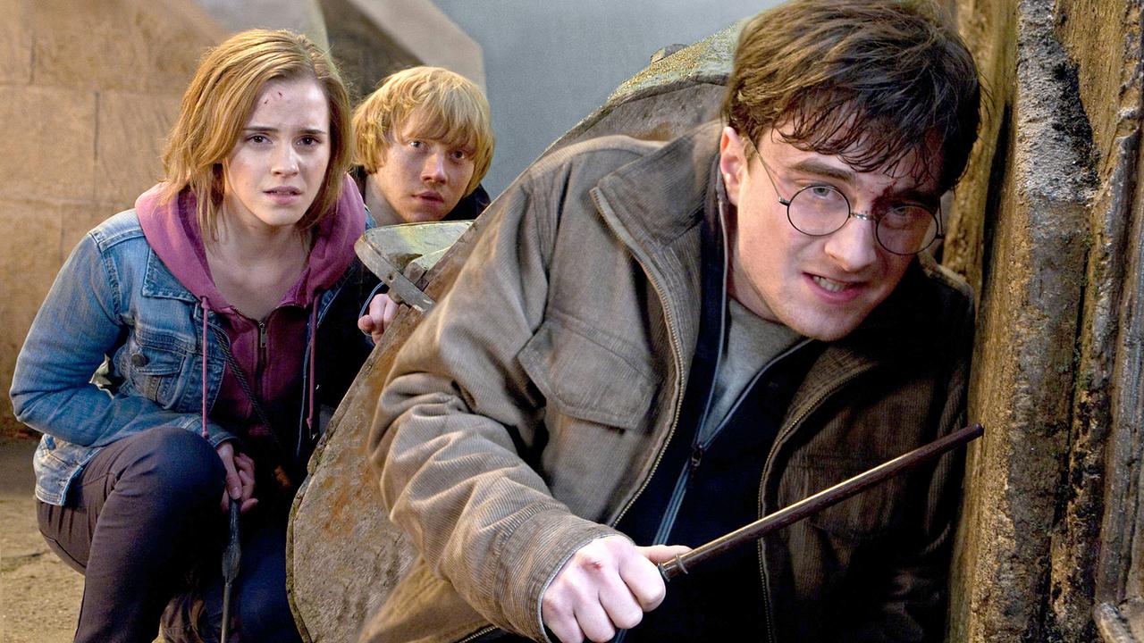 © ORF/TELE-München Hermine Granger, Ron Weasley und Harry Potter hocken im Schutz einer Wand, verzweifelt blicken sie um die Ecke, Harry hält einen Zauberstab in der Hand