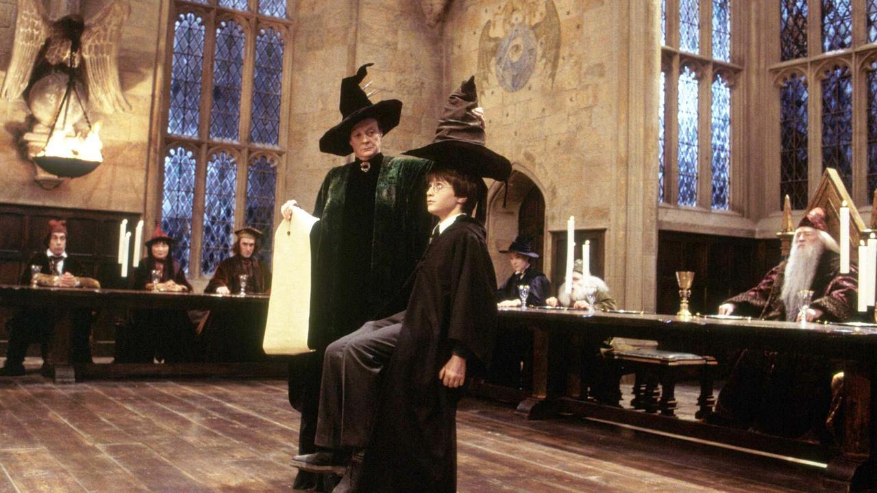Professor McGonagall (Maggi Smith) setzt Harry Potter (Daniel Radcliffe) den Sprechenden Hut auf. Er bestimmt jedes Jahr, auf welches der vier Häuser die neuen Erstklässler aufgeteilt werden.