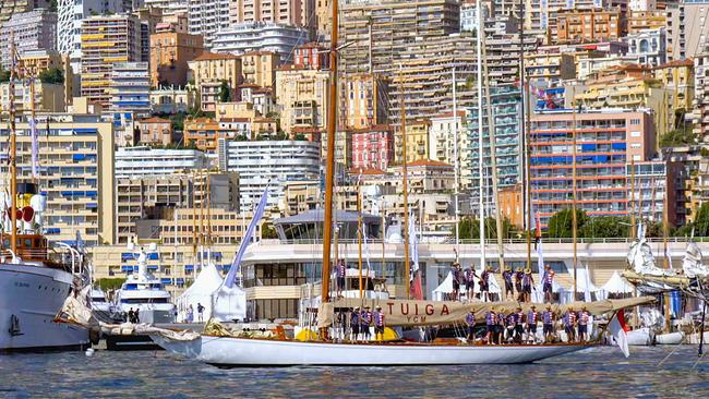 Ein historisches Segelboot im Hafen von Monaco, vor der Kulisse bunter Hochhäuser der Stadt