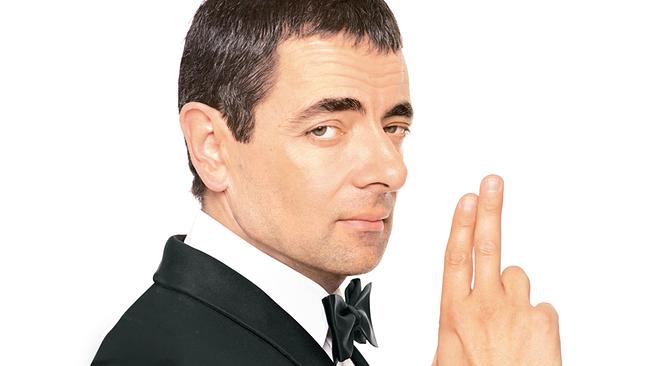 © ORF/Universal Rowan Atkinson als Johnny English im Smoking, weißen Hemd und schwarzer Masche, cool blickt er über seine linke Hand, mit der er mit Daumen, Zeige- und Mittelfinger eine Pistole andeutet