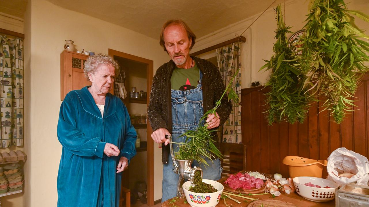 Im Bild: Papa Eberhofer (Eisi Gulp, r.) greift kurzerhand zum Fleischwolf, um ein paar ganz besondere Fleischpflanzerl zu kreieren. Oma Eberhofer (Enzi Fuchs, l.) beobachtet das Ganze eher skeptisch.