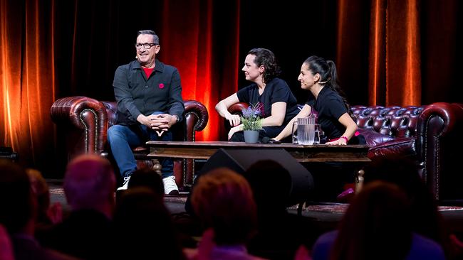 © ORF/Vienna Arts Management/Monika Fellner Viktor Gernot, Gudrun Nikodem-Eichenhardt und Caroline Athanasiadis sitzen auf Ledersofas auf einer Bühne vor orange beleuchteten Vorhängen bei der Jubiläumsshow.