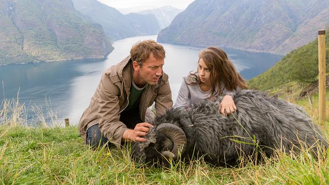 © ORF/Paramount Pictures/dieFilm GmbH/Majestic Filmproduktion GmbH/Georges Pauly Ein Mann und ein Mädchen streicheln ein schwarzes Hornschaf auf einer Wiese mit Blick auf einen norwegischen Fjord