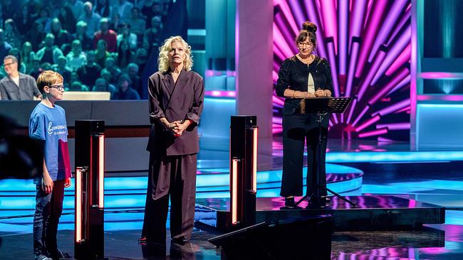 Emil, Ina Müller in der Mitte und eine weitere Frau stehen im Chor-Duell vor einem leuchtenden, pink-violetten Hintergrund