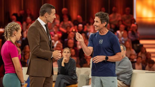 Mia (13), Kai Pflaume und Felix Gottwald stehen in einem hell ausgeleuchteten Studio und unterhalten sich vor einem Publikum.