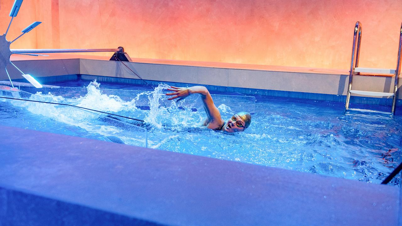 Franziska van Almsick schwimmt beim Schwimmbecken-Duell in einem Pool unter orange-blauer Beleuchtung.