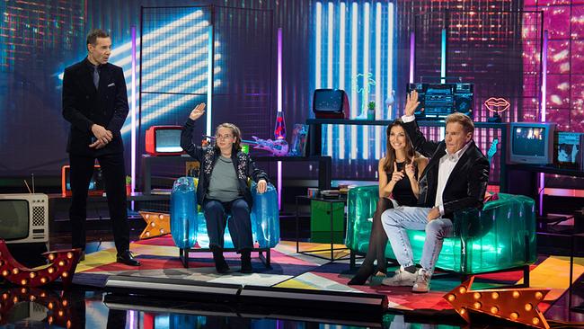 In einem bunt beleuchteten Retro‑Studio sitzen Ameli sowie Corina und Dieter Bohlen beim Musikvideo-Duell auf Sesseln, während Kai Pflaume danebensteht.