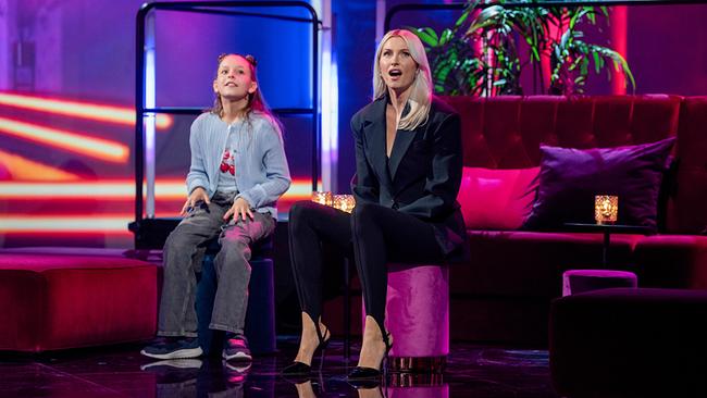 © ORF/NDR/MBTV - Produktions GmbH/Thorsten Jander Emma (10) und Lena Gercke sitzen beim Handmusik-Duell nebeneinander in einer violett beleuchteten Lounge im Studio.