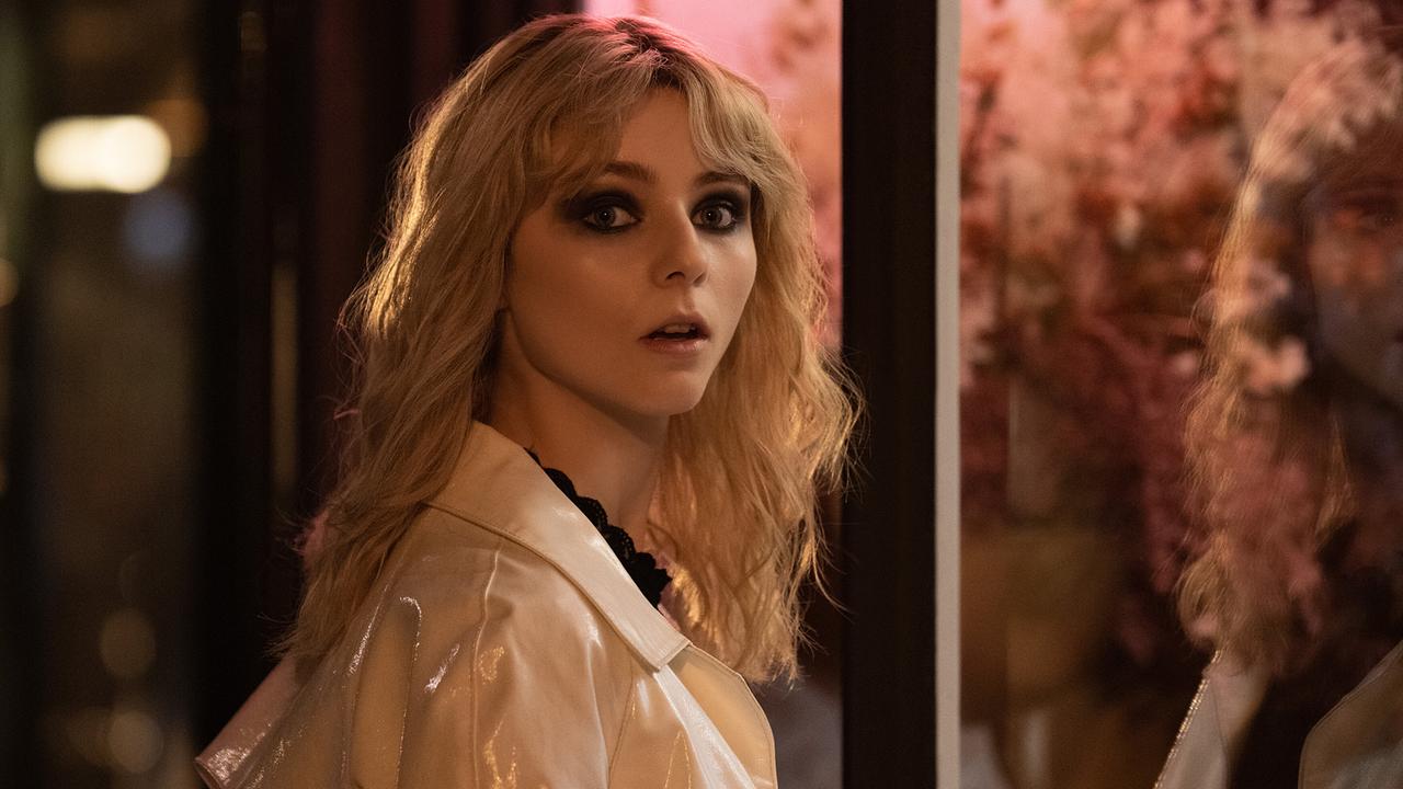 © ORF/Universal Pictures Eine blondhaarige, junge Frau in einem weißen Mantel, steht in der Nacht auf vor einer beleuchteten Auslageund blickt erstaunt über ihre Schulter zurück