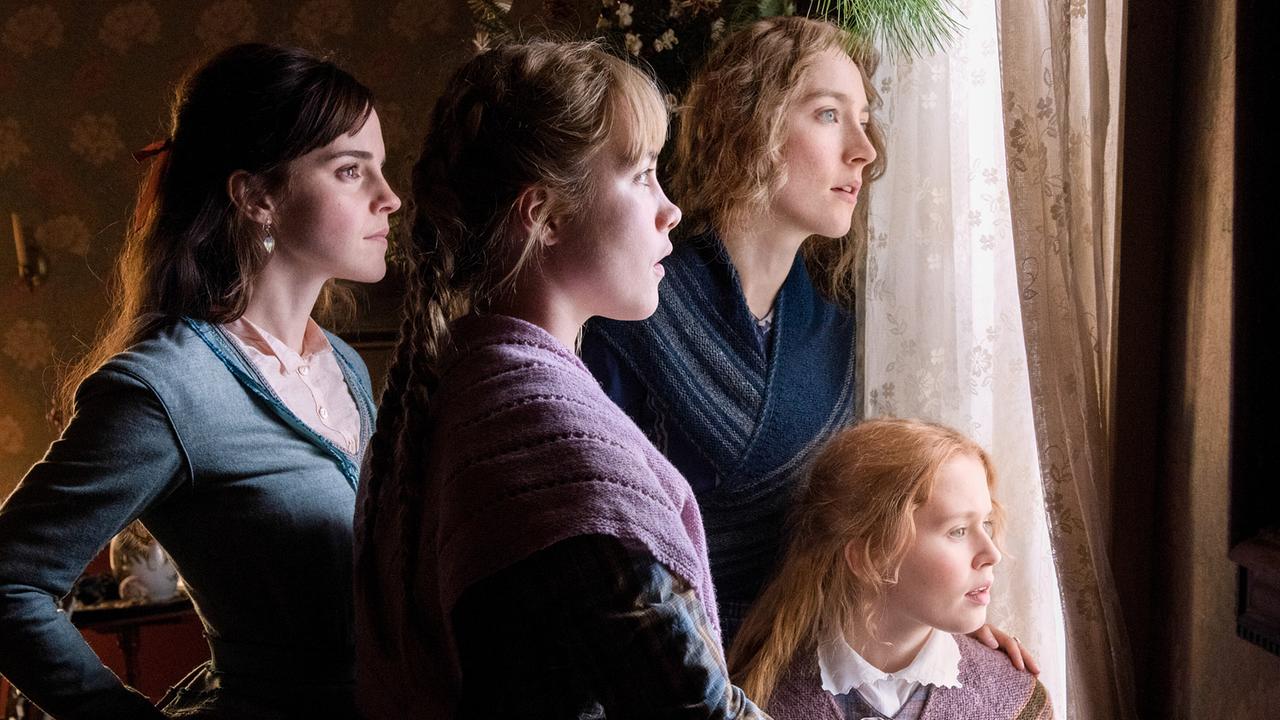 Vier junge Frauen stehen am Fenster und blicken durch den Vorhang nach draußen