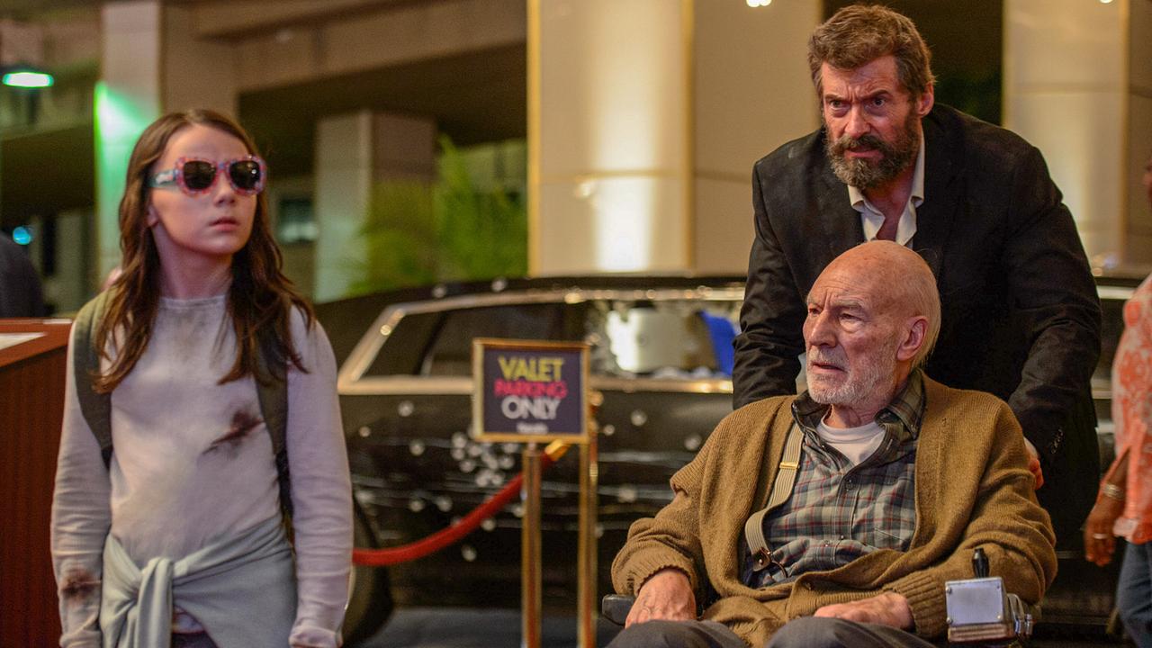 Ein Mädchen trägt in der Nacht eine Sonnebrille geht in einen Hoteleingang, Wolverine mit Charles Xavier im Rollstuhl folgt ihr