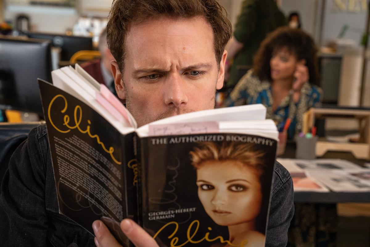 Sam Heughan als Journalist Rob Burns, bei seiner Arbeit studiert er eine Biogafie von Superstar Celine Dion