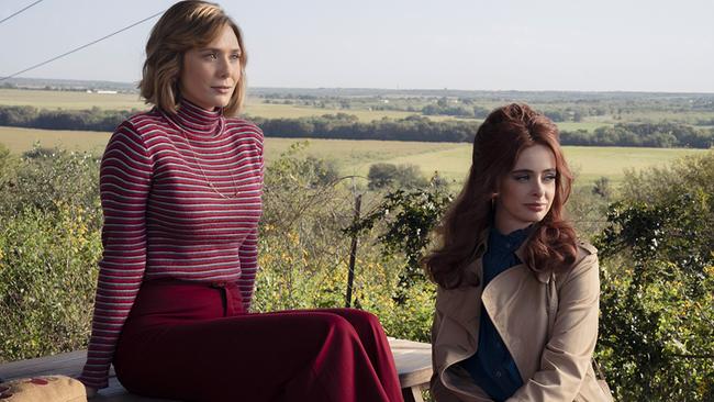 Elizabeth Olsen als Candy Montgomery und Krysten Ritter als Sherry Cleckle, die beiden Freundinnen machen auf einem Hügel auf einer Bank im Freien eine Rast, beide blicken freundlich lächelnd in dieselbe Richtung, hinter ihnen der Blick in die Ebene, Äcker, Wiesen und Wälder sind zu sehen