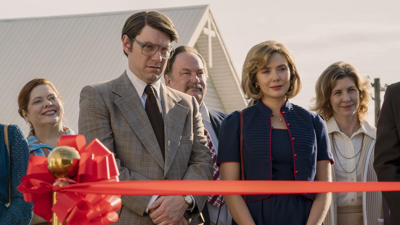 © ORF/Warner/HBO Max Patrick Fugit als Pat Montgomery und Elizabeth Olsen als Candy Montgomery bei einem öffentlichen Terminn, vor ihnen ein gespanntes rotes Band, hinter ihnen lächelnde Mitfeiernde