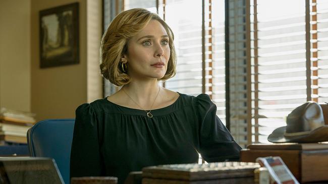 Elizabeth Olsen als Candy Montgomery, in einem dunkelgrünen Kleid sitzt an einem Schreibtisch und blickt ihrem Gegenüber ernst und gefasst entgegen