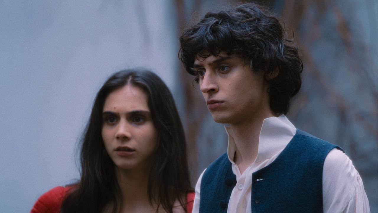 © ORF/WDR/Story House Pictures/Armands Virbulis Wolfgang Amadeus in Weste und weißem Hemd, steht neben Maria Anna mit langem dunklen Haaren und rotem Kleid, beide blicken nach vorn