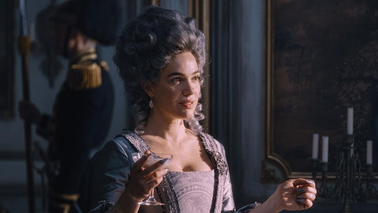 © ORF/WDR/Story House Pictures/Armands Virbulis Verena Altenberger als Marie Antoinette in prunkvoller historischer Kleidung, sie hält ein Glas und steht in einem elegant dekorierten Raum