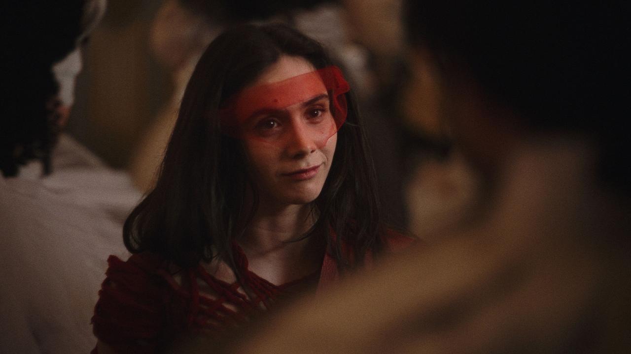 © ORF/WDR/Story House Pictures Maria Anna Mozart inmitten einer Menschenmenge bei schwachem Licht, als Maske trägt sie einen durchsichtigen roten Schleier vor ihren Augen