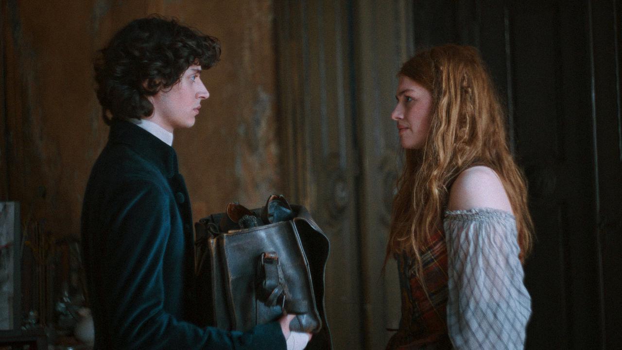 Wolfgang Amadeus in dunkler Kleidung steht Constanze gegenüber, beide schauen sich distanziert an, er hält eine große Tasche in den Händen