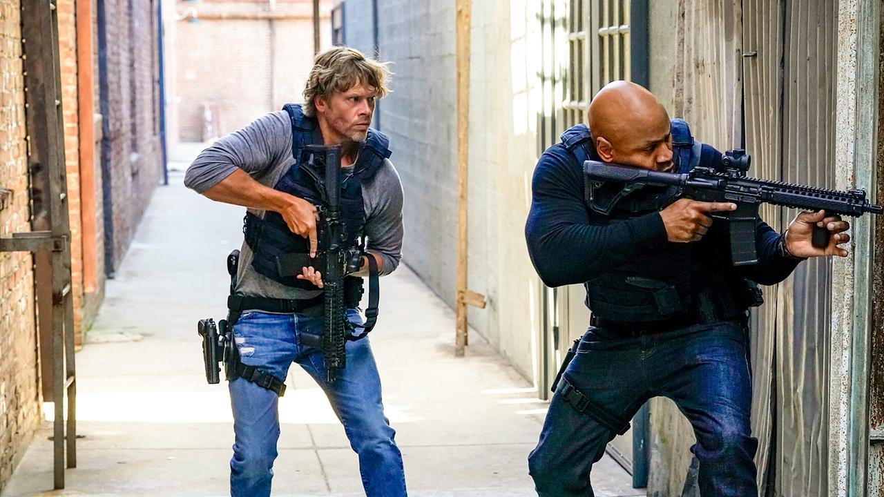 © ORF/Sevenone International/CBS/Robert Voets Investigator Marty Deeks und Special Agent Sam Hanna im Einsatz, aus einer Gasse blicken sie um die Hausecke, Hanna hält die Waffe im Anschlag