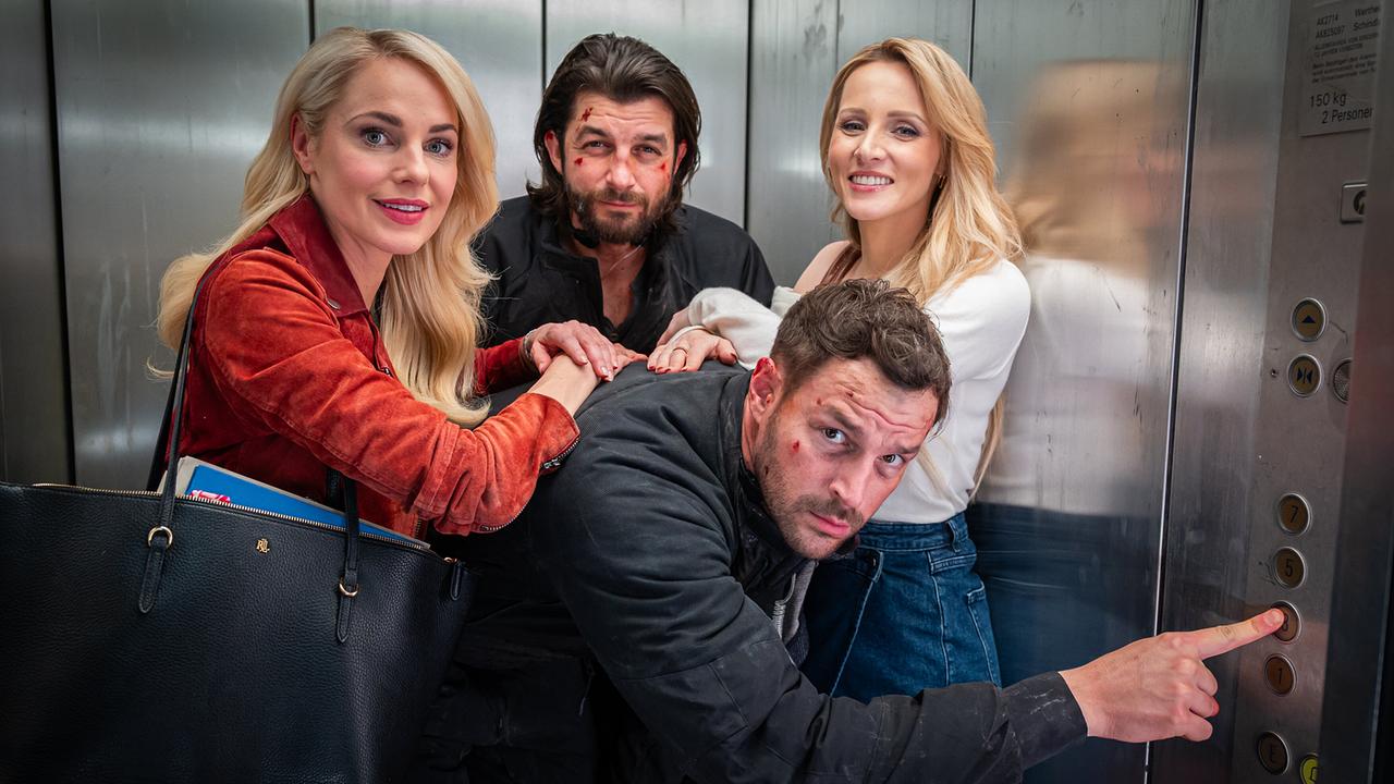 Alice Gneisser, Eddi Kovac, Flo Kienzl und Trixi Mooswaldner posieren in einem engen Aufzug.