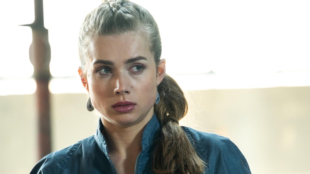 Domenica Tschatsch mit zusammengebundenen Haaren trägt einen dunkelblauen Overall und blickt ernst zur Seite.