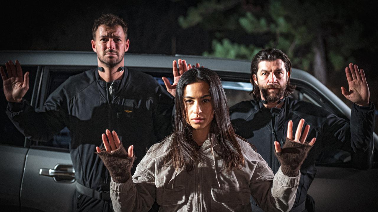 Flo Kienzl, Samira Leoni und Eddi Kovac heben nachts vor einem Wagen die Hände und ergeben sich.