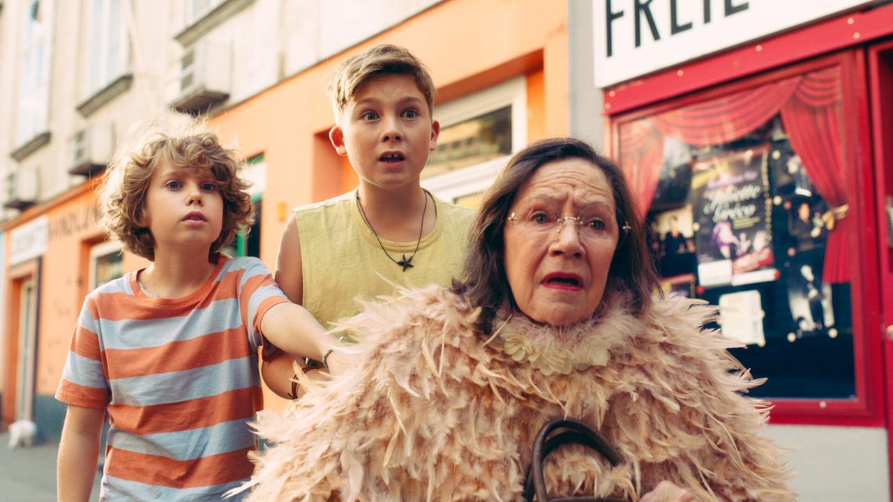 Franz und Eberhard stehen hinter der verschreckten Frau Berger auf der Straße.