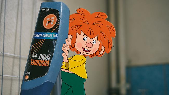 Pumuckl füllt Duschgel in die Waschmaschine.