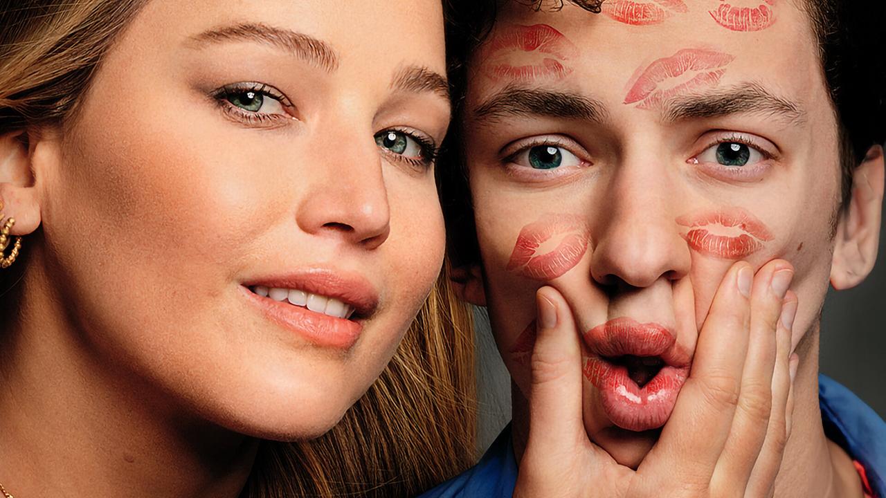 Jennifer Lawrence als Maddie und Andrew Barth Feldman als Percy blicken direkt in die Kamera, sie wirkt herausfordernd und drückt seine Wangen mit einer Hand, er blickt erstaunt drein, sein Gesicht ist von Lippenstiftabdrücken von Küssen übersät