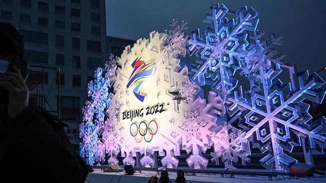 - A man answers a phone call in front of an installation displaying the logo of the Beijing 2022 Winter Olympic Games, along a street in Beijing on January 21, 2022