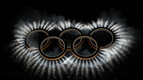 Die von Feuerwerk umgebenen Olympischen Ringe vor dunklem Hintergrund während der Eröffnungsfeier der Olympischen Winterspiele Milano Cortina 2026 im San-Siro-Stadion in Mailand