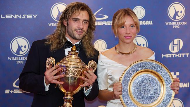 Toby Sebastian als Andre Agassi und Lena Klenke als Steffi Graf, in festlicher Kleidung halten sie ihre Siegestrophäen in den Händen, hinter ihnen eine Werbewand mit der Aufschrift WIMBLEDON 1992
