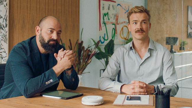 David und Matthias führen gemeinsam die Agentur "My Companion" und sitzen an einem Tisch in der Agentur.