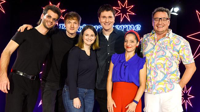 Benjamin Nyamandi, Felix Kramer, Evelin Pichler, Hosea Ratschiller, Caro Athanasiadis und Didi Sommer posieren vor einer bunt beleuchteten Bühne mit Sternmotiven und "Pratersterne"-Schriftzug im Hintergrund.