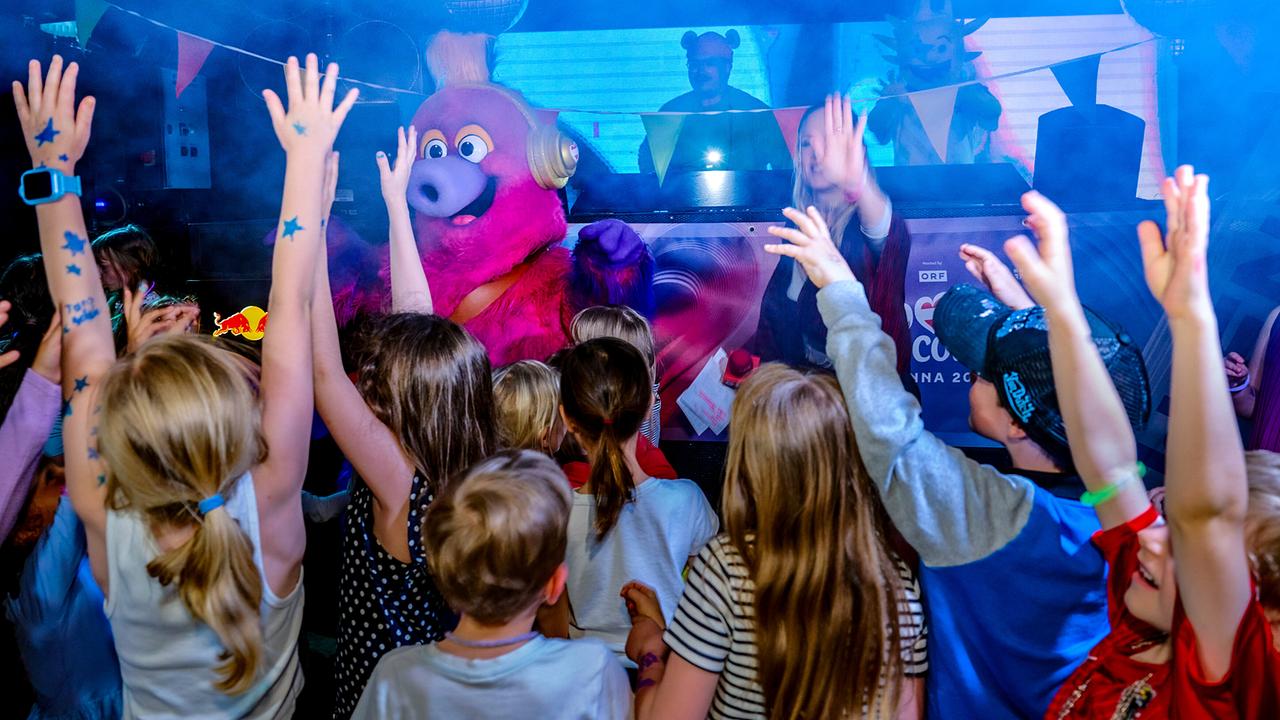 Lilian Klebow zu Besuch bei der großen Kinderdisco, wo Kinder gemeinsam mit ESC-Maskottchen Auri tanzen.