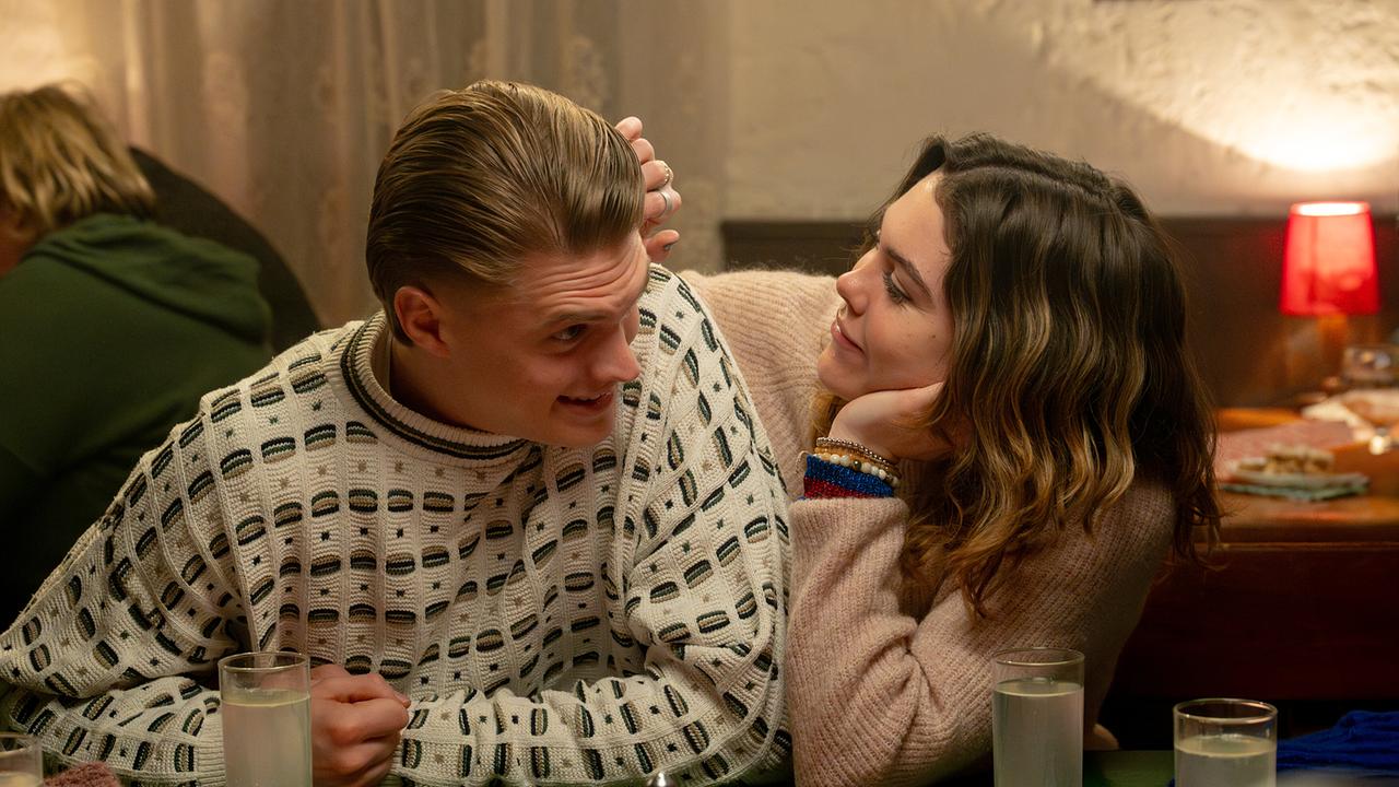 Bobby Harrer sitzt neben Solenn Eden, die ihn mit der Hand am Kopf streichelt, an einem Tisch in einem Gasthaus.