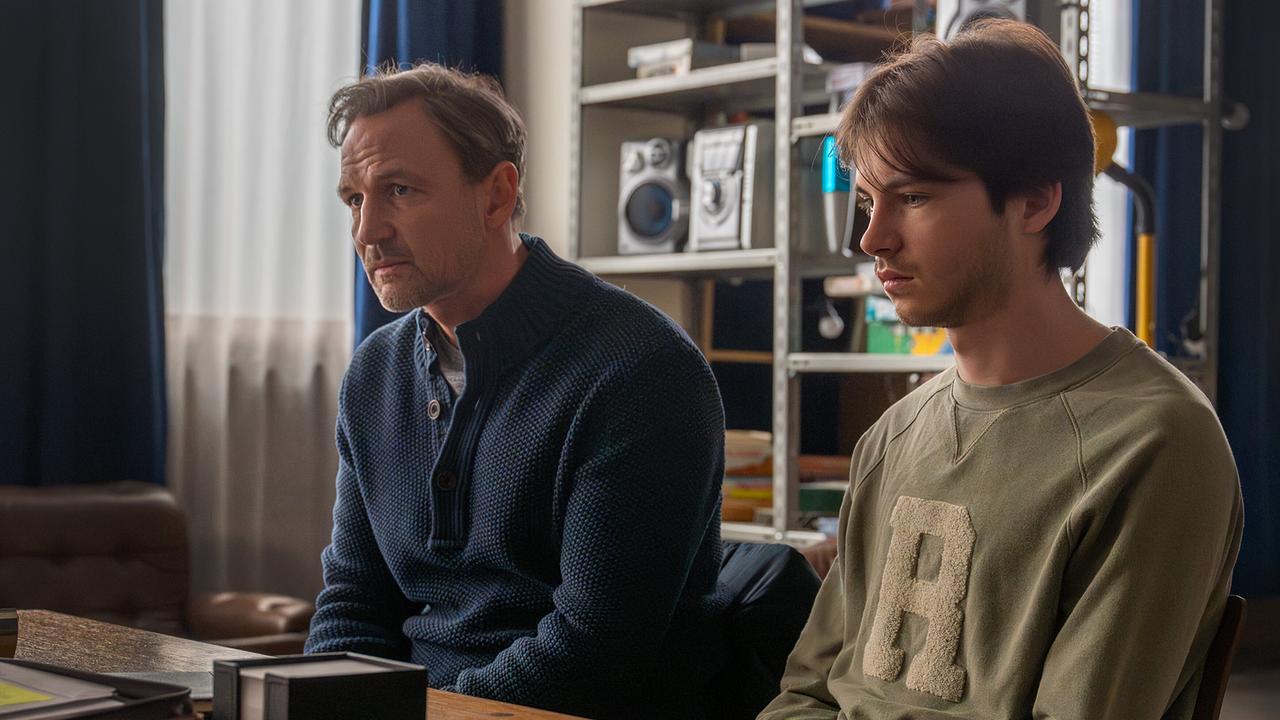 Mario Rossi und Luca Rossi sitzen nebeneinander an einem Schreibtisch jemandem gegenüber.