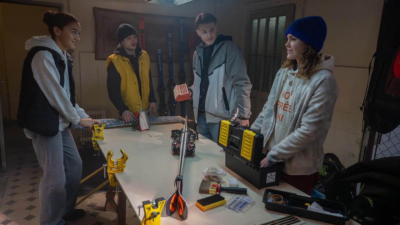 Nawal Ammann, Nikki Auer, Bobby Harrer und Solenn Eden stehen in einer Werkstatt um einen Tisch zusammen und arbeiten an einer Skiausrüstung.