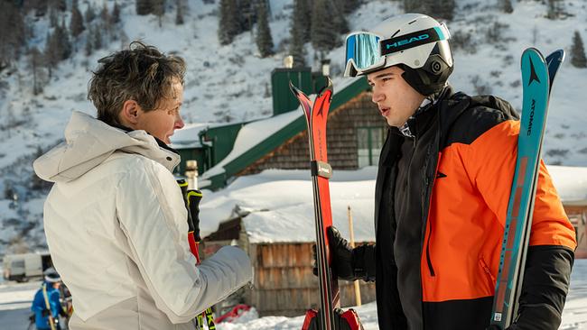 Jutta und Georg Stoiber, beide in Winterkleidung, stehen sich im Freien in schneebedeckter Landschaft gegenüber und halten Skier in der Hand.