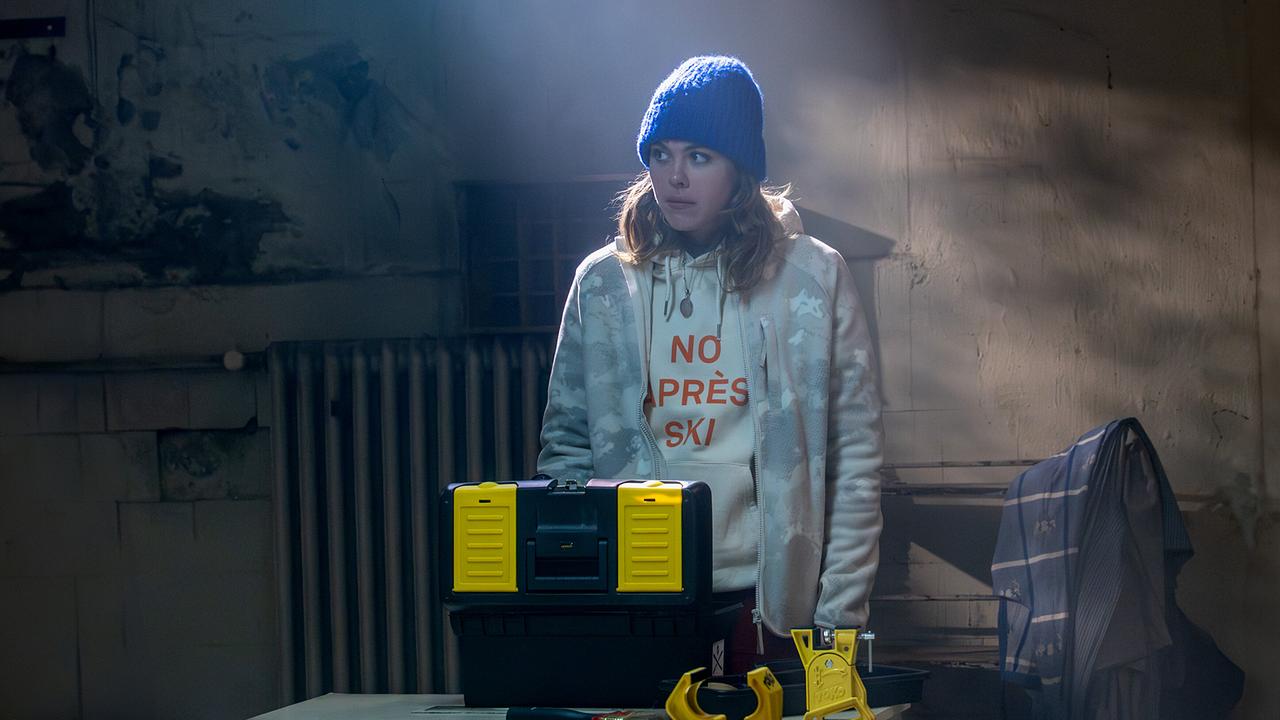 Solenn Eden steht in einem Skikeller mit einem Werkzeugkasten vor ihr.