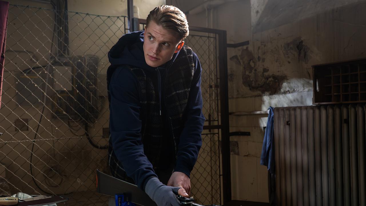 © ORF/BR/Superfilm/Stefanie Leo Bobby Harrer arbeitet in einer Werkstatt an seinen Skiern, umgeben von Werkzeug und Maschinen.