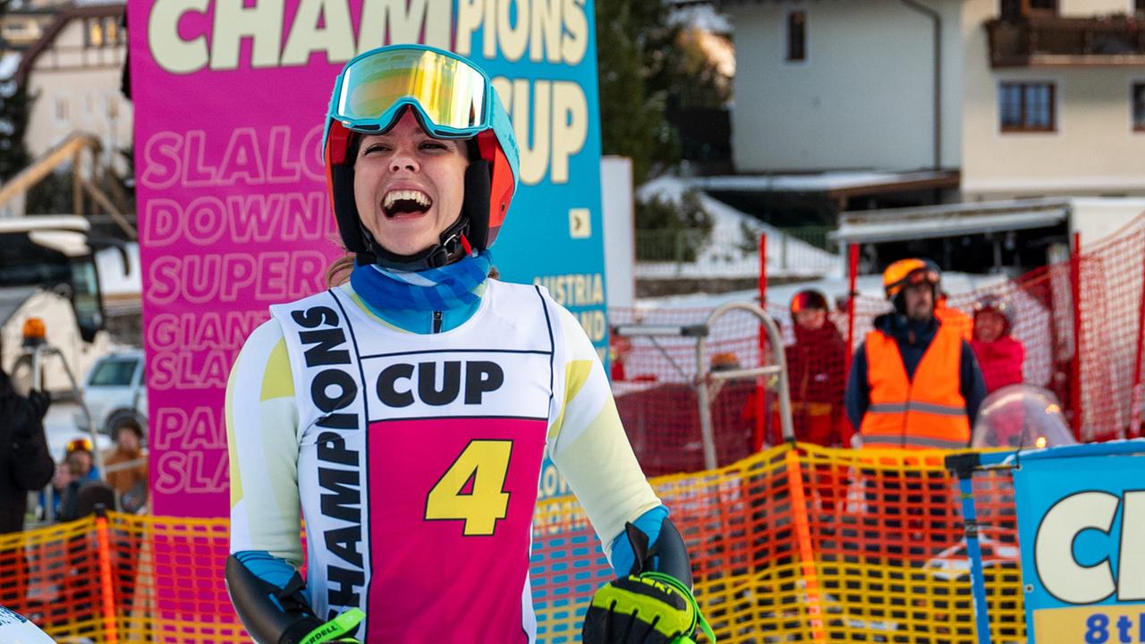 Solenn Eden im Skirennanzug steht mit Startnummer 4 vor einem bunten „Champions Cup“-Banner im Startbereich der Strecke.