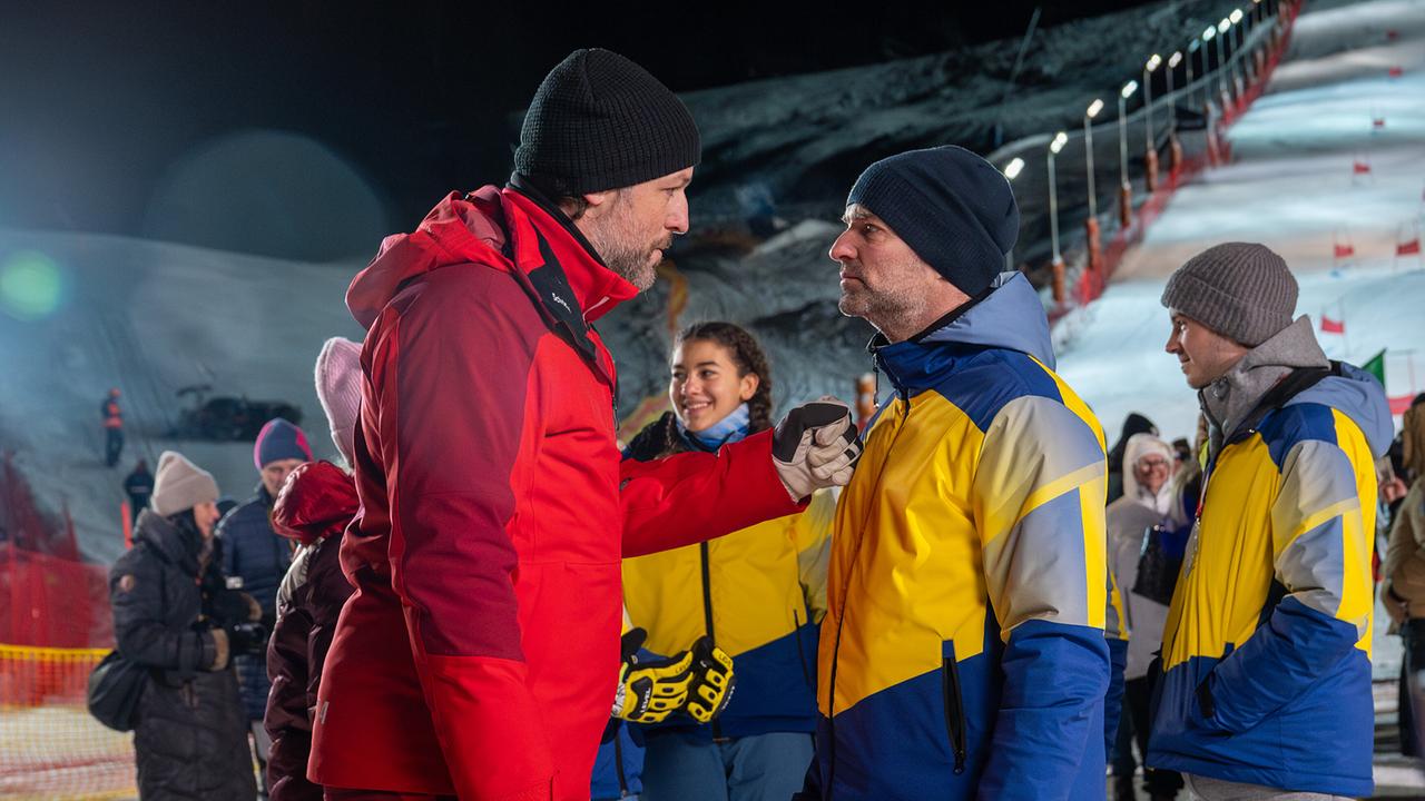 Christian im Gespräch mit Mark Auer im Zielbereich eines Nachtrennens, im Hintergrund stehen weitere Menschen.