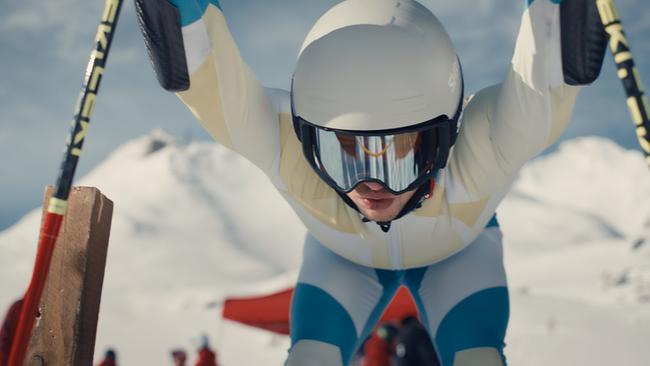 Skirennläufer Nikki Auer beugt sich im Startgate kraftvoll nach vorne, bereit zum Rennstart.