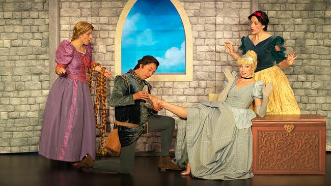 In einer märchenhaften Bühnenkulisse hilft Julian Loidl als Prinz einer Prinzessin in den Schuh, während Rapunzel mit ihrem langen Zopf und Schneewittchen danebenstehen.