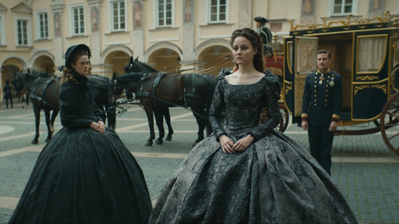 © ORF/Beta Film/RTL /Story House Pictures Sisi (Dominique Devenport, Mi.) und Kaiser Franz (Jannik Schümann, r.) betrauern den Tod ihrer Tochter Sophie. Sisis Schwester, Herzogin Helene (Pauline Rénevier, l.), teilt den Schmerz des Kaiserpaars
