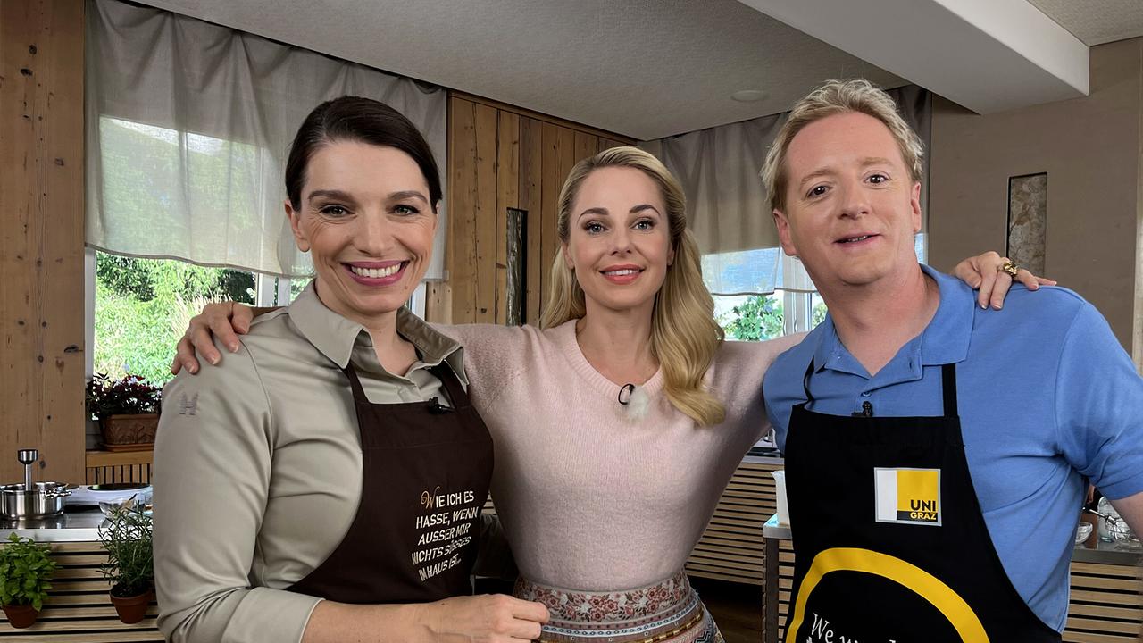 © ORF/On Media Eveline Wild, Silvia Schneider und Fritz Treiber stehen in einer Küche und verkosten Kaiserschmarrn.