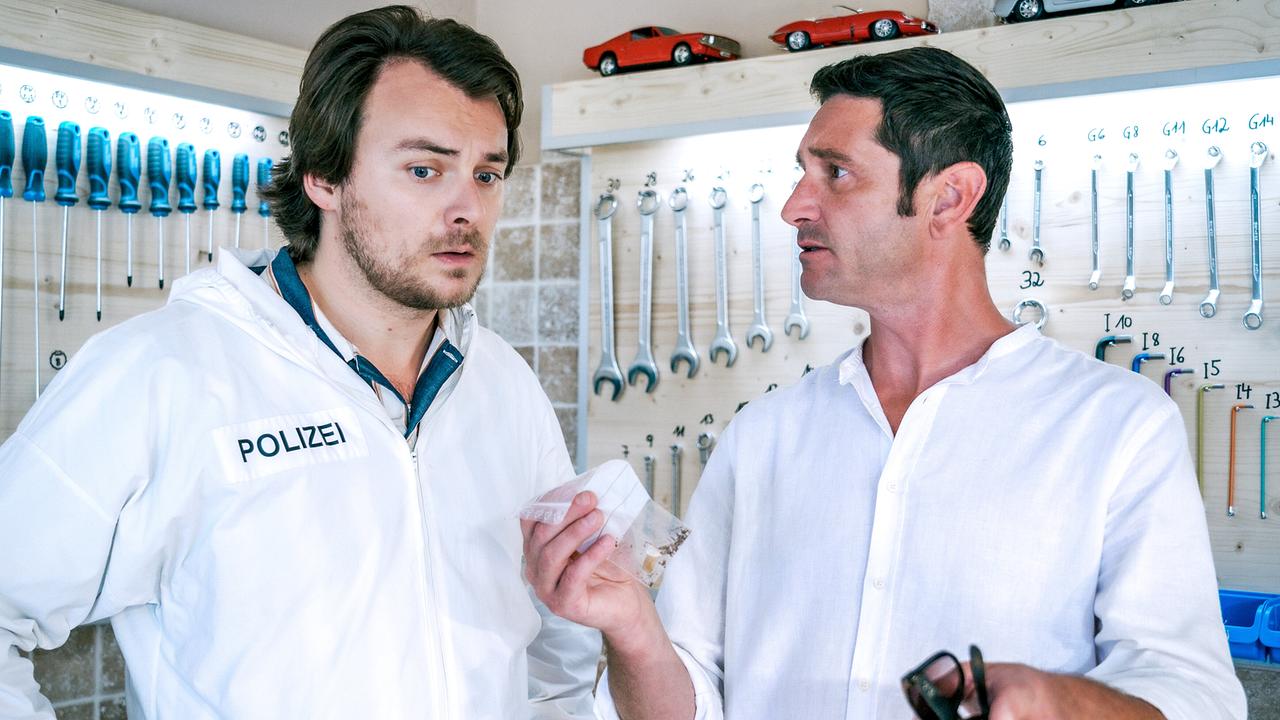 © ORF/Satel Film/Petro Domenigg In der Garage zeigt Klaus Lechner dem Forensiker Julius Rubatsch ein Beweisstück in einem Beutel.